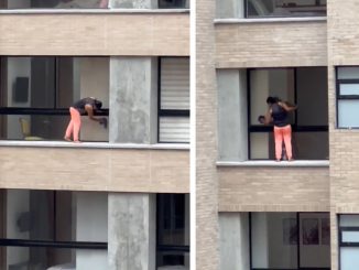 Mujer limpiando ventalanes en edificio de El Poblado